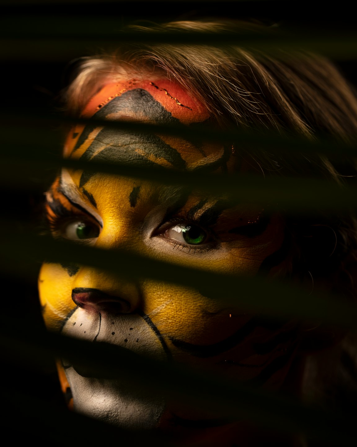 Person with tiger face paint looking to the side.